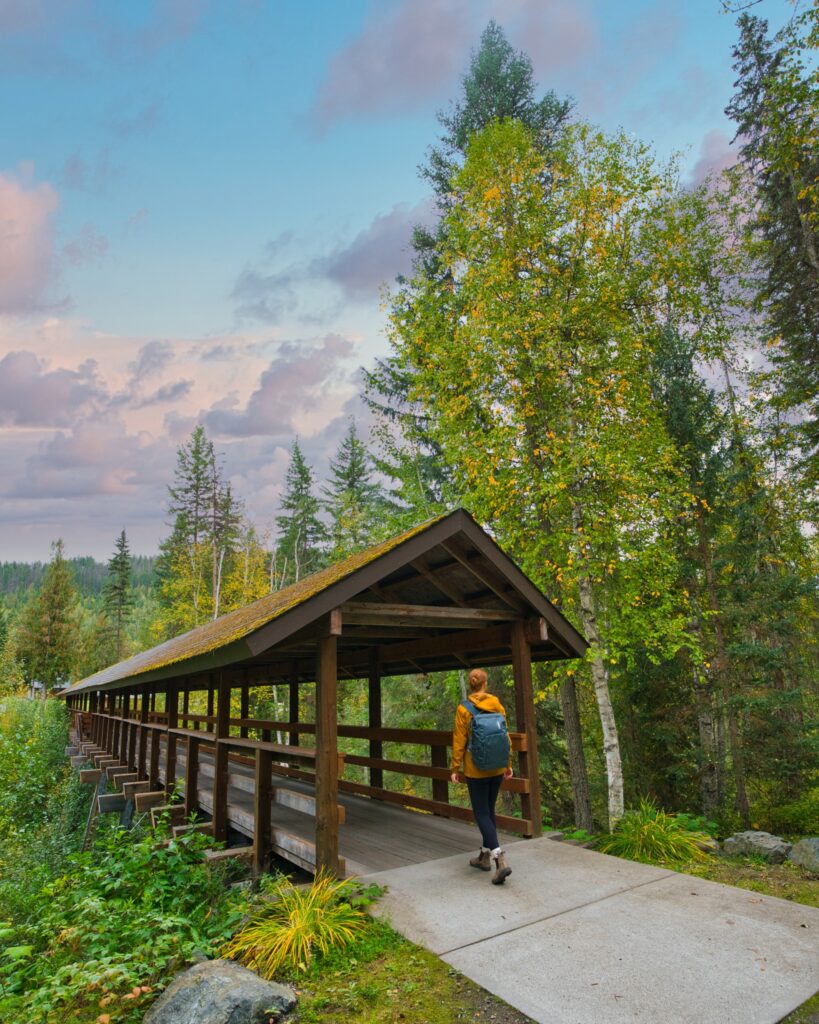 A woman walks through a wooden bridge at Alpine Meadows Resort British Columbia