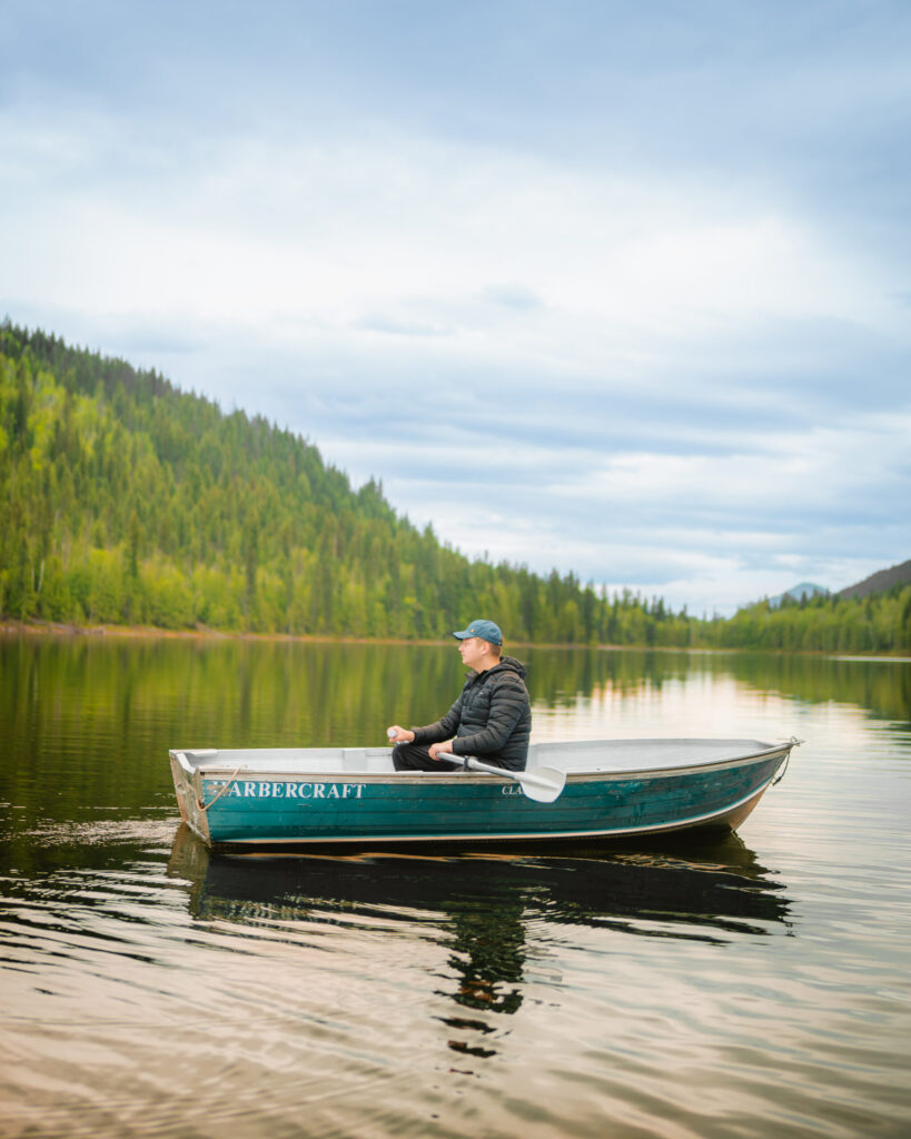A man sits in a rowboat on Hallamore Lake at Alpine Meadows Resort British Columbia