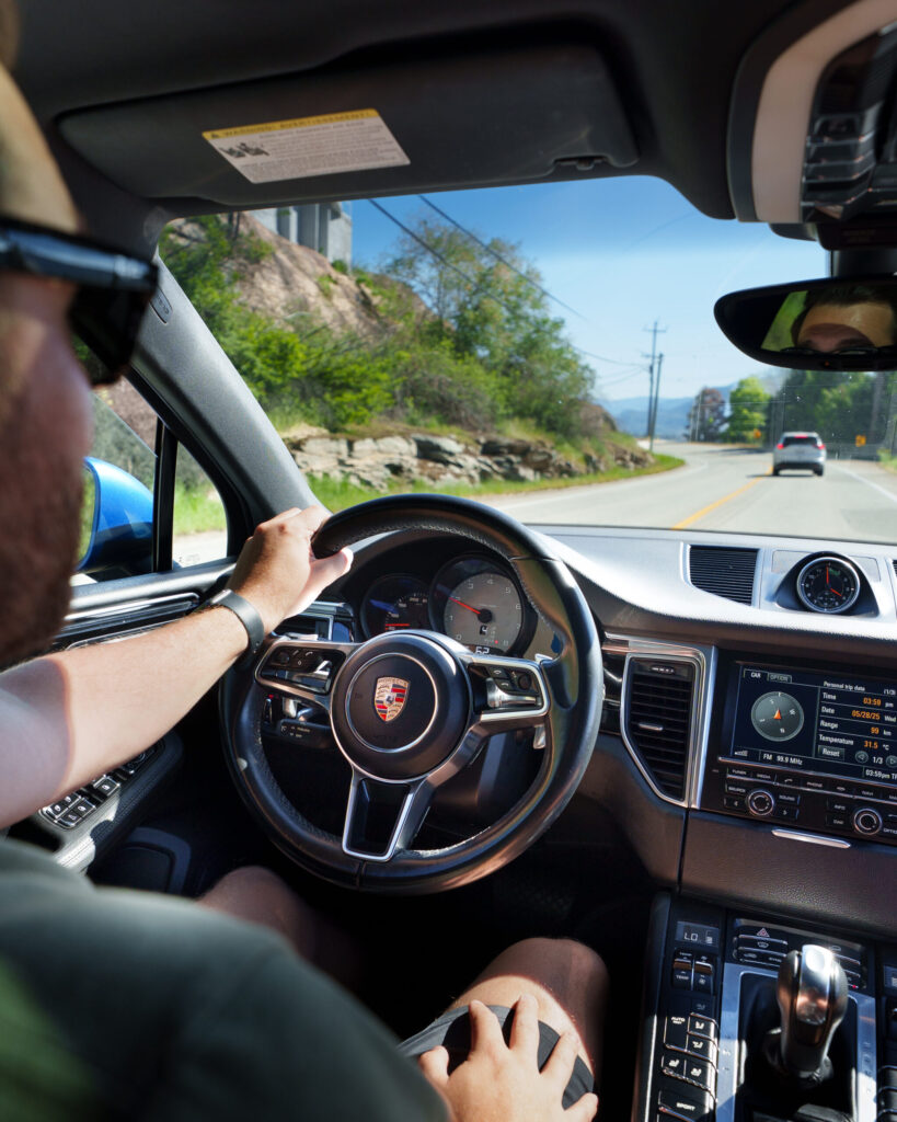 a man drives a Porsche through the streets of Naramata, British Columbia