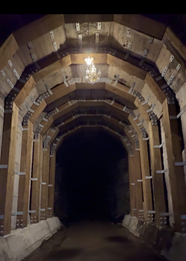 The historic Adra Tunnel on the KVR Trail in Naramata, British Columbia. The wooden frame outlines the tunnel as it fades into darkness.
